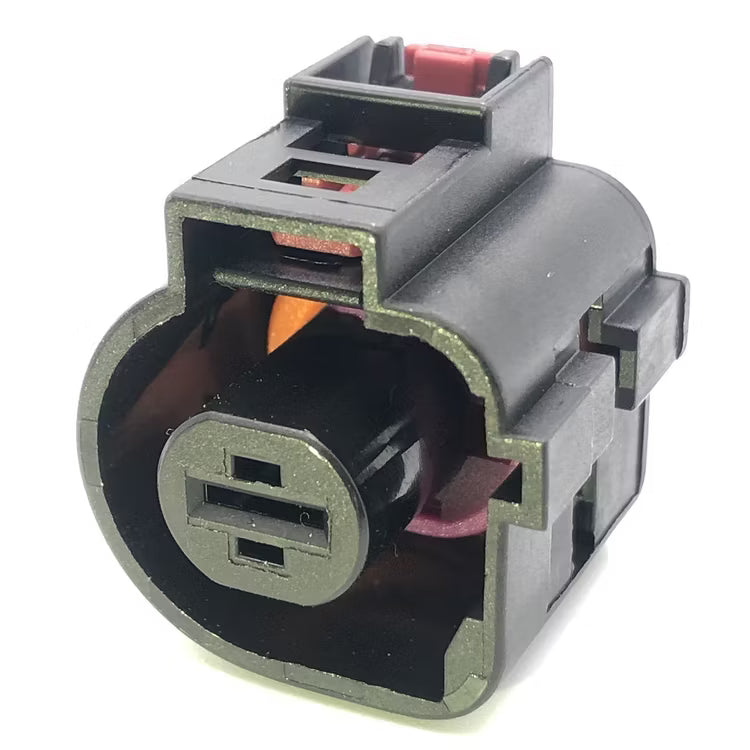 A black plastic electrical connector with a circular front plug and visible internal red and orange components, isolated on a white background.